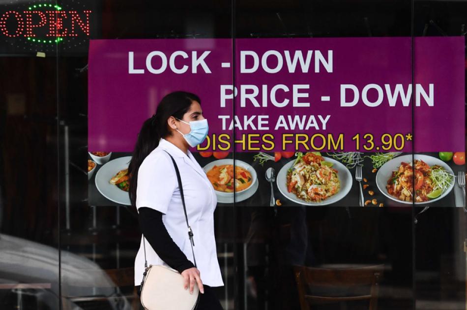 Images of the Day:A woman wearing a face mask walk ...