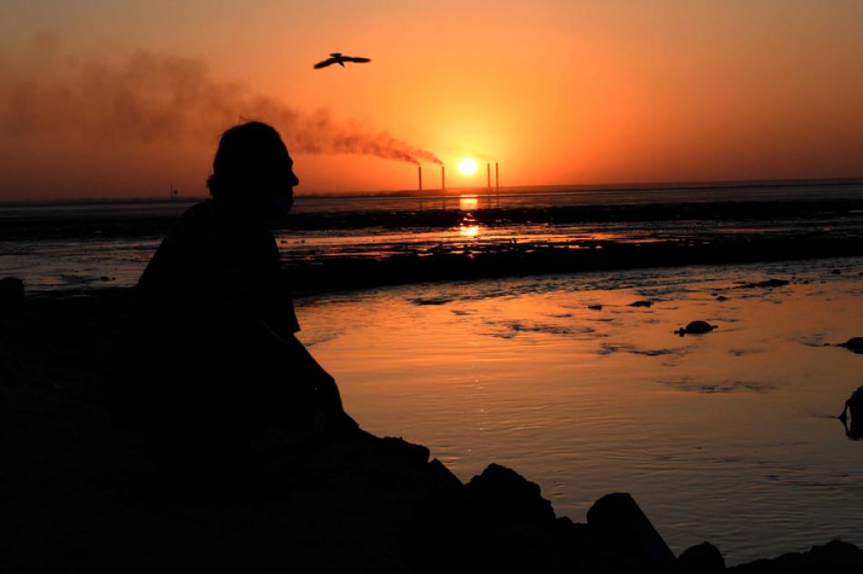 Images of the Day:A local resident sits on the beach during sunset in Kuwait City