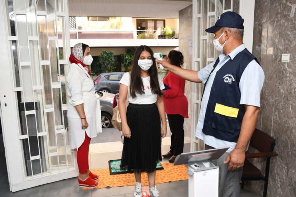 Images of the Day:Morocco: Student wearing a mask has her temperature checked before attending a class in school