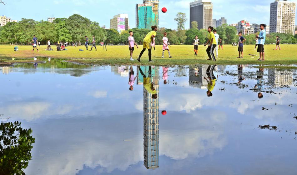Boys play football in Kolkata's rain-washed urban  ...